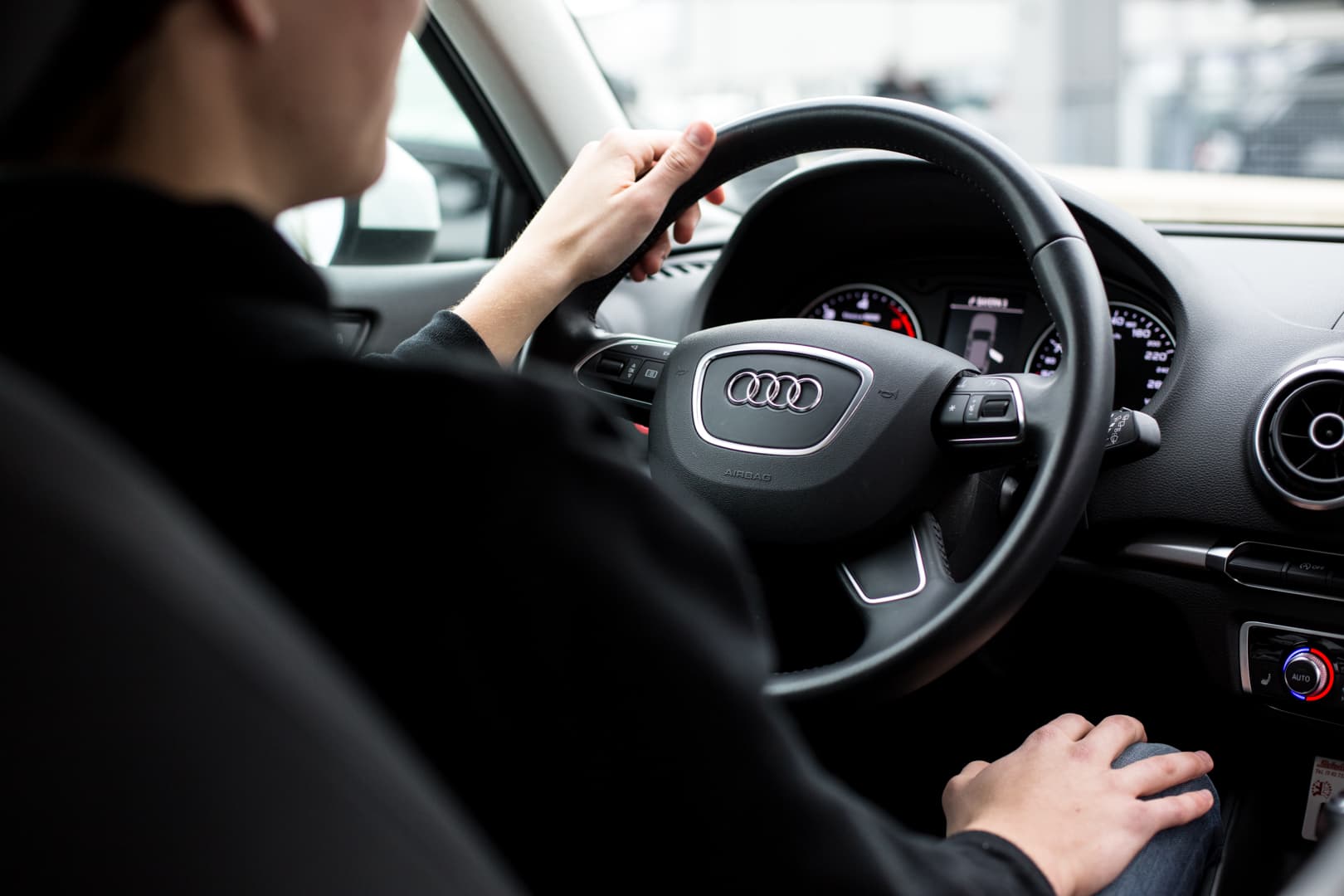 Fahrschülerin sitzt entspannt am Lenkrad eines Fahrschulwagens