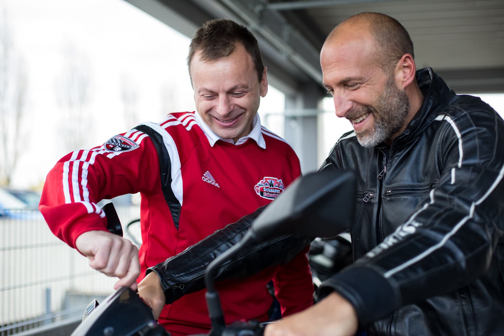 Fahrlehrer erklärt einem Fahrschüler das Motorrad
